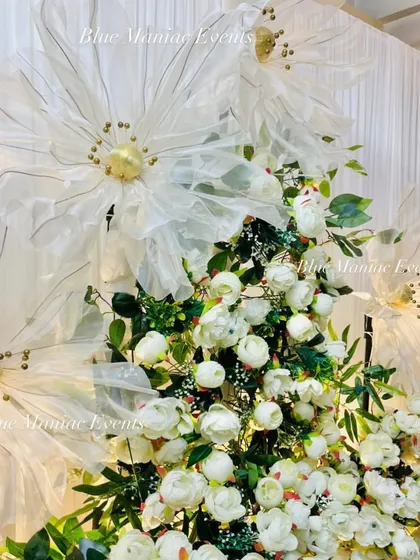 A close-up of a unique floral design for an engagement. This setup features large, artistic, translucent flowers mixed with dense white artificial blooms, creating a dreamy and textured backdrop.