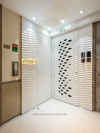 This modern apartment entrance features a hidden door crafted from Corian. The 3D wavy panel flows across the wall and door, creating a seamless, artistic facade that conceals the entrance with architectural finesse.