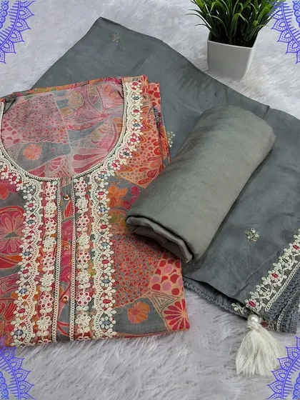 A sophisticated grey dress material with a digital print top featuring Kalamkari-inspired motifs. The simple dupatta with a delicate border completes this elegant set.
