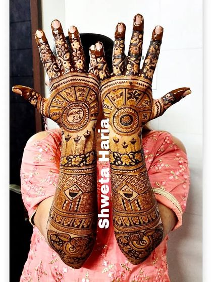 A unique bridal back-hand design featuring circular mandalas with the wedding date and initials, surrounded by intricate patterns.