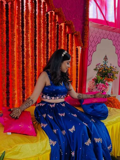Another beautiful shot of Supritha, enjoying her mehendi ceremony in a vibrant setting.