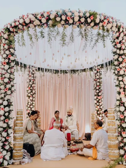 The serene setting of Mohit and Shikha's beachside wedding ceremony, under a beautiful floral arch.