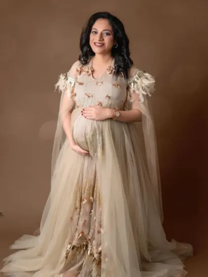 A full-length portrait in our elegant beige gown with a sheer cape and delicate embellishments, perfect for a sophisticated look.