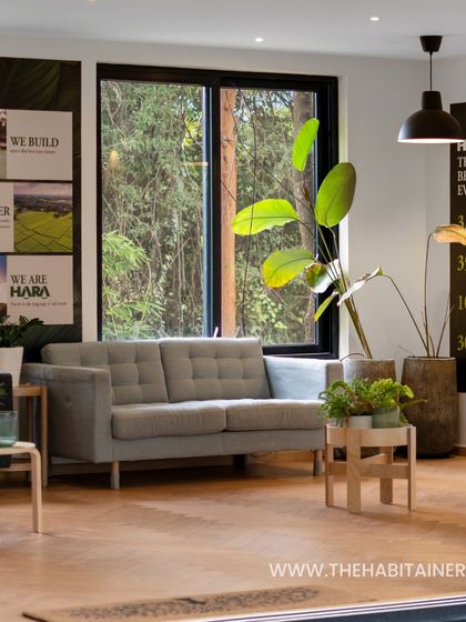 A view into a container office, showing a comfortable waiting area with modern furniture and lots of natural light.