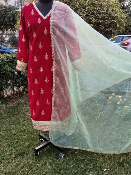 Another view of the red velvet suit, showing how the light and airy net dupatta beautifully contrasts with the heavy, luxurious velvet.