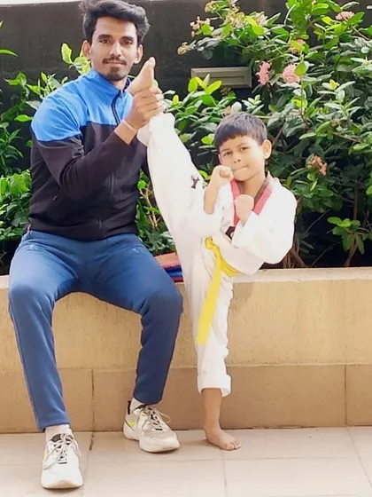 Working one on one with a young student to perfect his high kick. This pose shows great flexibility and my hands on coaching style.
