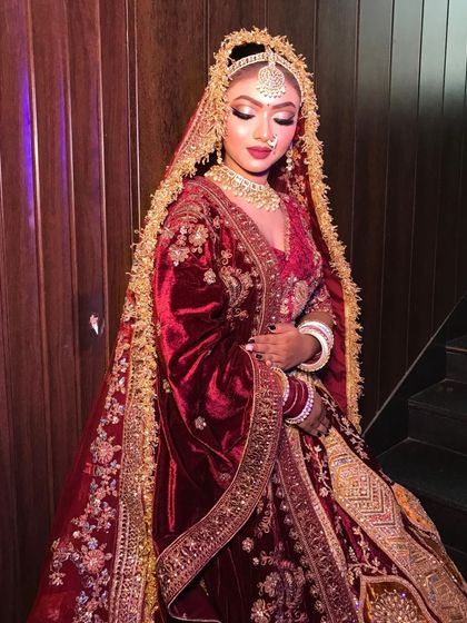 Another angle of the maroon doli lehenga, showing the rich texture of the velvet and the detailed gold embroidery.