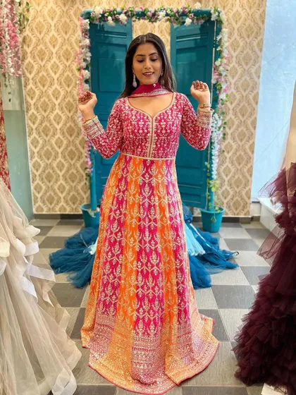 Another look at this gorgeous pink and orange gown. The vibrant colors and intricate work make it a standout piece that you can rent for your special day.