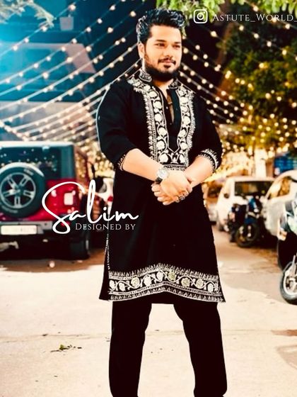 A client in a black kurta with beautiful silver embroidery on the neckline and hem. A classic and versatile piece for any celebration.