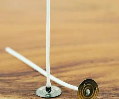 This is a close-up of a pre-tabbed cotton wick. The metal tab at the base provides stability, making it easy to place and secure the wick at the bottom of your candle jar.