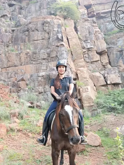 This rider is framed by a massive rock formation, a common feature of the ancient Aravali mountain range. Our trails take you through diverse and dramatic geological landscapes.