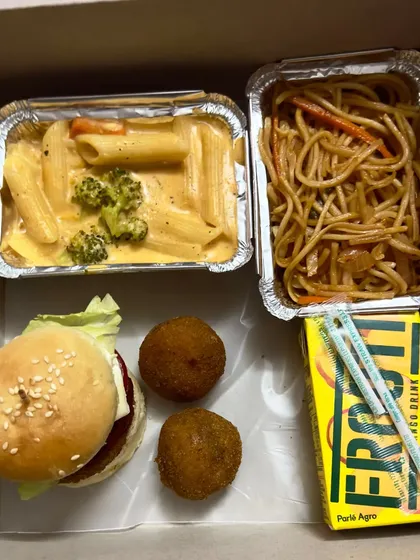 Here's another example of a customised kids' snack box. It includes a mini veg burger, cheese balls, creamy pasta, and a Frooti, making it a fun and filling treat for any children's event.