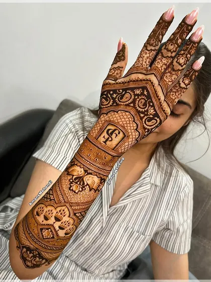 Another example of personalization, this time with the initials 'S' and 'F' set within a traditional frame on the back of the hand.