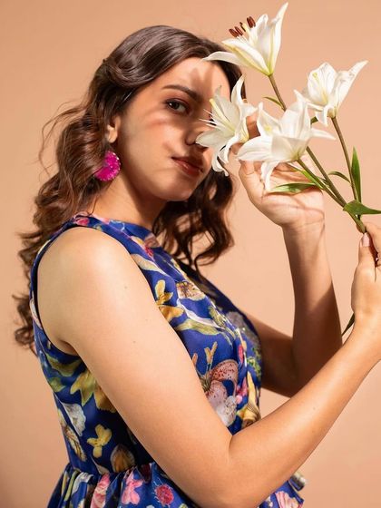 A close-up from the Riddhi Jain shoot, showing the soft, peachy tones on the cheeks and lips. The makeup enhances the model's natural beauty without overpowering the delicate floral theme.