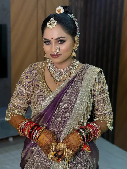 A royal purple Nauvari saree look, complemented by a detailed hair bun and traditional Maharashtrian jewellery.