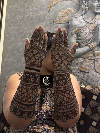 The back of the hands for a baby shower celebration. The design is full and intricate, matching the festive spirit of the event, with leafy patterns and geometric fills.