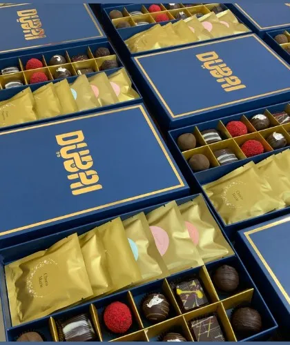 Our custom corporate chocolate boxes are designed to impress. These elegant blue boxes with gold foil branding are filled with an assortment of gourmet chocolates and wafers.