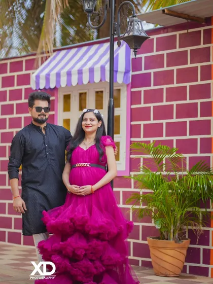 A stylish couple posing against a colorful brick wall, exuding a cool and confident vibe.