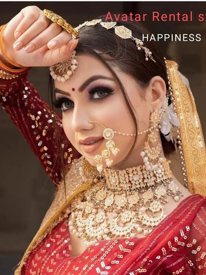 A beautiful close-up of a bride in a red lehenga, showcasing the flawless makeup and a complete gold jewellery set, all from my studio.