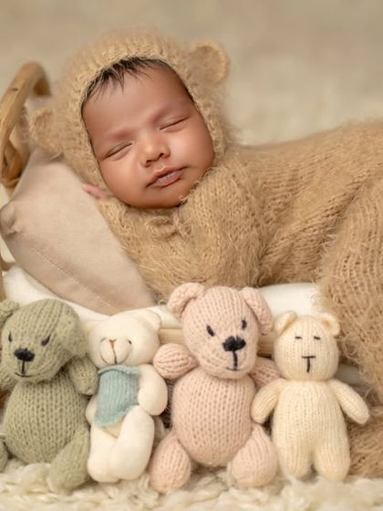 The full lineup of teddy bears watching over this sleeping baby. A fun and adorable setup for a newborn session.