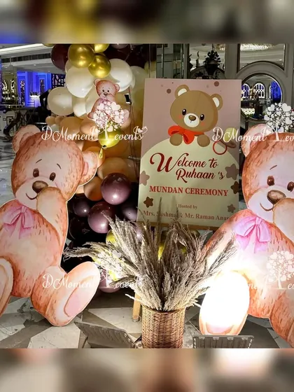 A welcome sign for Ruhaan's Mundan ceremony, flanked by two large, adorable teddy bear cutouts and a basket of pampas grass, combining cute and boho elements.