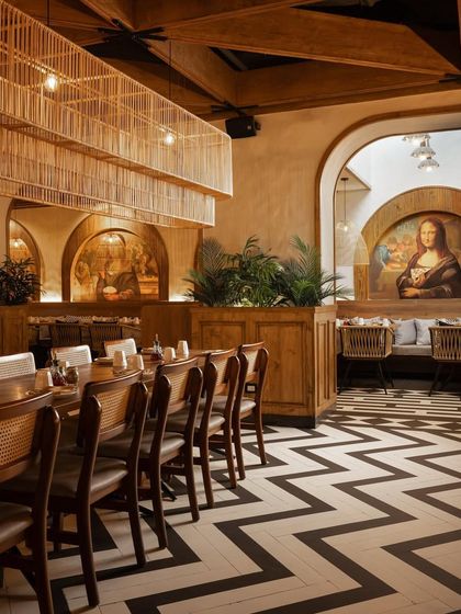 The combination of patterned floors, arched murals, and warm wood creates a space that feels both familiar and fresh.