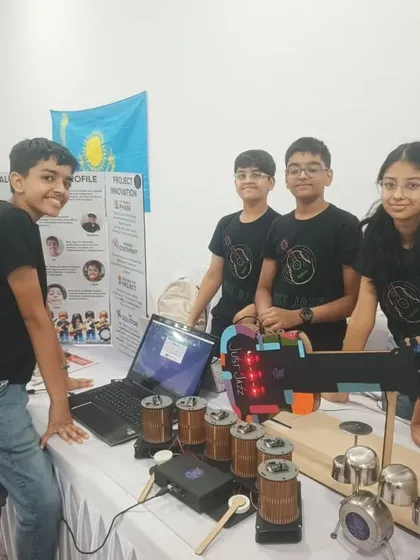 Team 'Just Jazz' showcasing their automated musical instrument project. This FLL Challenge entry uses robotics to play a variety of instruments, demonstrating complex programming and mechanical design.