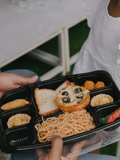 A close-up of a party meal box, filled with tasty treats like pasta, mini pizzas, and sandwiches. We make sure every part of the party experience is delightful.