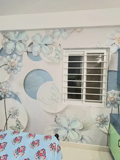 This bedroom features a charming 3D wallpaper with light blue flowers and butterflies, creating a sweet and dreamy atmosphere.