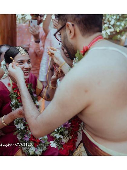 A key moment in a Tamil wedding ceremony, captured up close. The intimate setting allows for these beautiful, personal interactions.