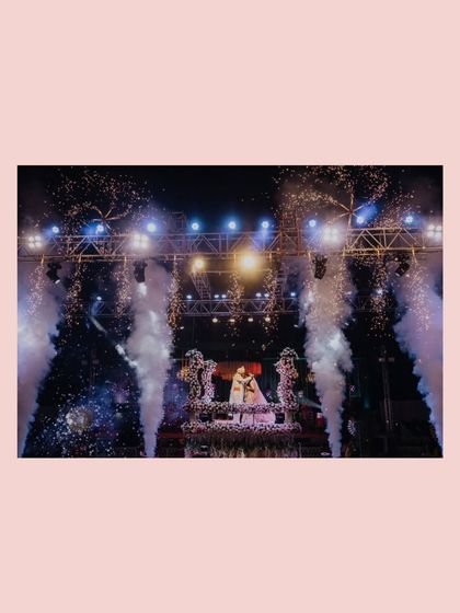 A wide shot of the grand stage with fireworks, capturing the epic scale of Aaisha and Hiten's celebration.