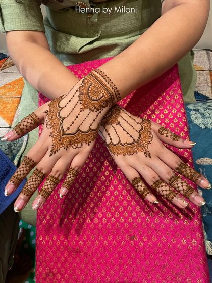 A classic 'bel' or vine pattern on the back of the hands, with detailed finger designs. This is a timeless and elegant choice.