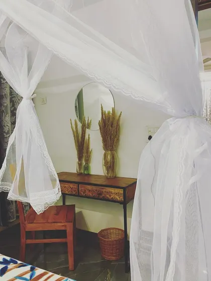 A sneak peek of the decor, with a view through the cabana's sheer curtains to a rustic console table.