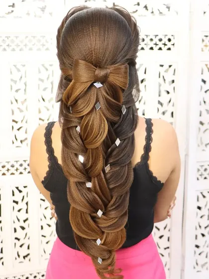 A mermaid braid hairstyle with a bow element. The hair bow adds a cute and playful touch to this otherwise intricate and dramatic braid.