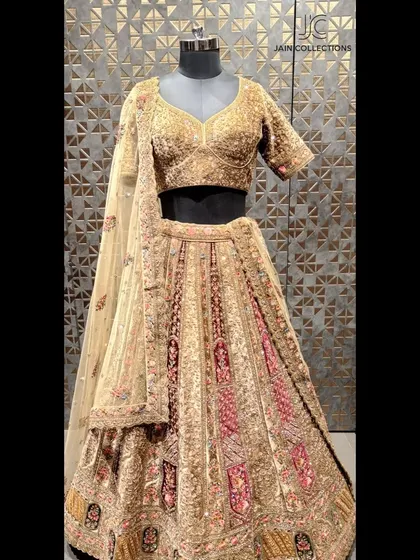 Displayed on a mannequin, this gold and maroon lehenga shows off its intricate patterns and luxurious fabric, a perfect choice for a traditional bride.