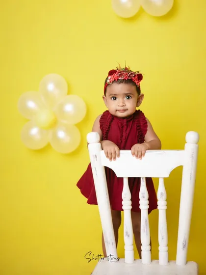The birthday girl stands proudly by her chair in this colorful and modern milestone shoot.