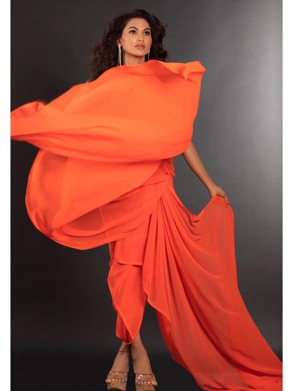 A studio shot capturing the movement and flow of a vibrant orange fabric. This artistic image is all about color, shape, and dynamic energy.