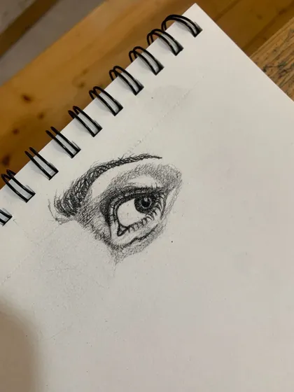 A detailed study of an eye in charcoal. We focus on capturing the reflection and depth that make a portrait feel alive.