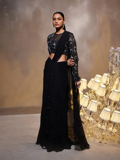 The Diana Saree Set in black, a testament to craftsmanship. The draped silhouette is paired with a meticulously hand-embellished, long-sleeved blouse.
