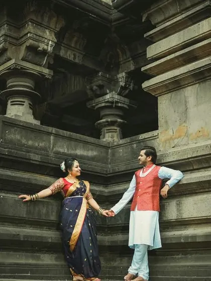 A powerful shot of a couple holding hands in front of a stunning, carved stone temple, showcasing their connection against a backdrop of history and tradition.