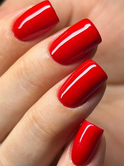 A classic, true-red manicure on short, square nails. The color is rich and vibrant, and the glossy finish is impeccable.
