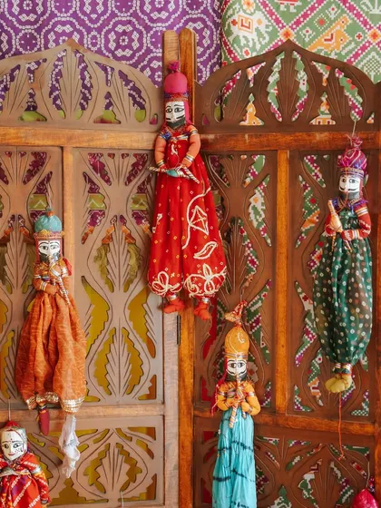 A collection of traditional Rajasthani puppets ('kathputli') used as a decorative element, celebrating the region's vibrant folk art traditions.