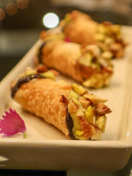 A fusion of Italian and Indian flavors. This is a crisp cannoli shell filled with decadent badam halwa and studded with slivered almonds and pistachios.