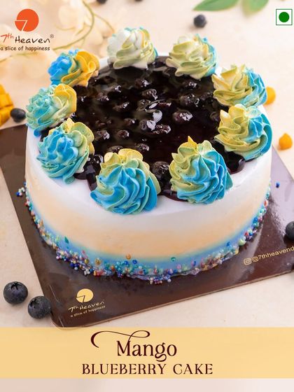 When mango meets blueberry, magic happens. This beautiful cake features a blueberry topping and is decorated with colorful blue and yellow frosting swirls.