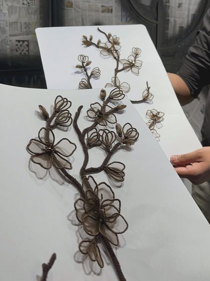 A sample board showing the handcrafted raffia and net florals. We create and review these detailed samples to perfect the color, scale, and texture before applying them to the final piece, ensuring every element is just right.