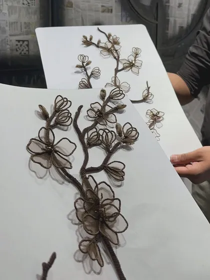 A sample board showing the handcrafted raffia and net florals. We create and review these detailed samples to perfect the color, scale, and texture before applying them to the final piece, ensuring every element is just right.