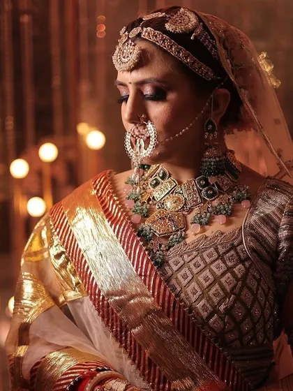 A timeless blend of heritage and craftsmanship. This bride wears an exquisite multi-layered polki and emerald set with a statement nath and sheeshpatti for her special day.