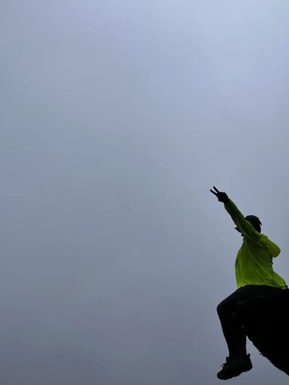 A silhouette of a trekker against the foggy sky, capturing the moody and atmospheric feel of a monsoon trek.