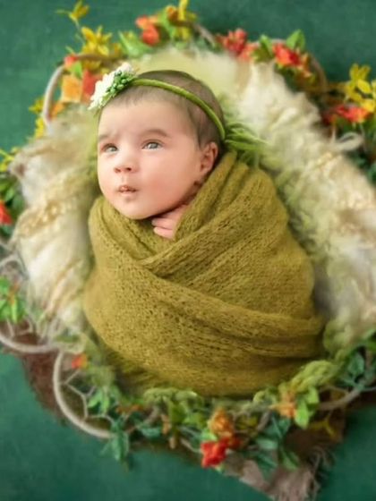 This 20-day-old baby is nestled in a green wrap within a rustic, leafy wreath. Even as they get a little older, we can still capture beautiful, sleepy portraits in creative setups.