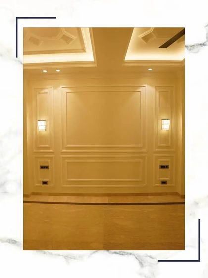 A beautifully executed wall with classic paneling and integrated sconce lighting, showcasing the standard of luxury we deliver.